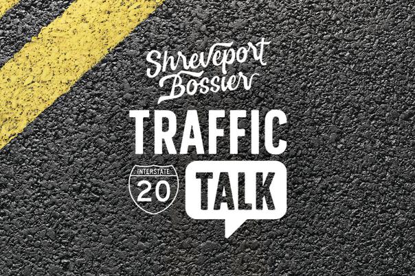 Pavement with yellow painted stripes in corner in background, Shreveport-Bossier I-20 Traffic Talk graphic in middle foreground