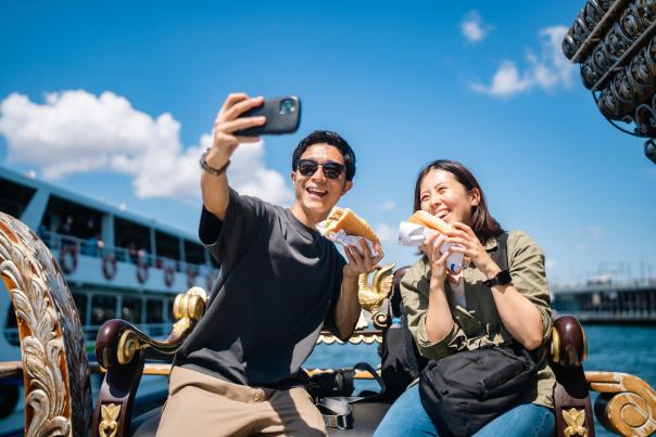 Tourist couple is taking a selfie with smart phone while eating street food