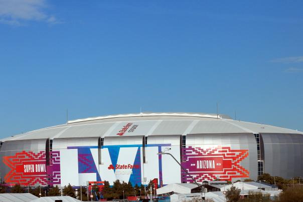 Super Bowl decals on the outside of a football stadium.