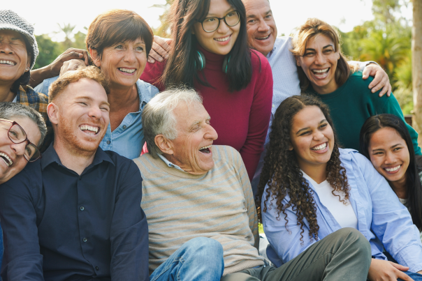 A group of 10 people from multiple generations smile together