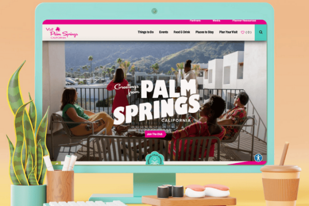 A teal colored desktop monitor mocked up with the Palm Springs website on it.