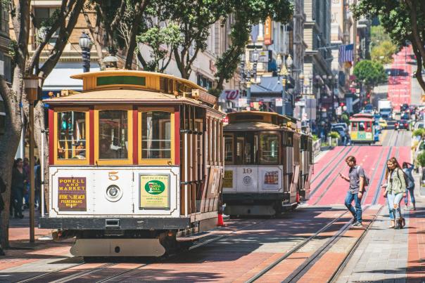 Powell and Market cable car going up a hill in sunny San Francisco.