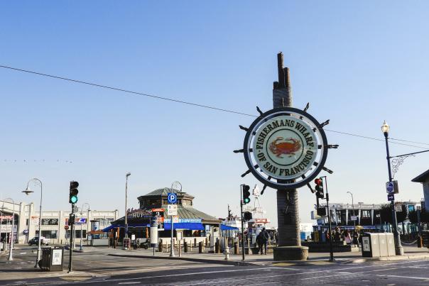 A sign at the entrance of Fisherman's Wharf on a sunny day in San Francisco.