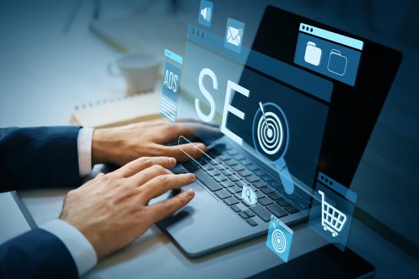 A person working on a laptop computer with the term "SEO" and other icons overlaid across the image.