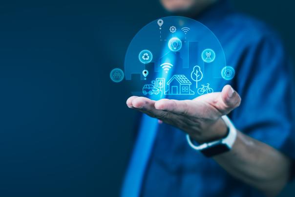 A person holding out their extended hand with digital icons inside of a sphere graphic overlay.