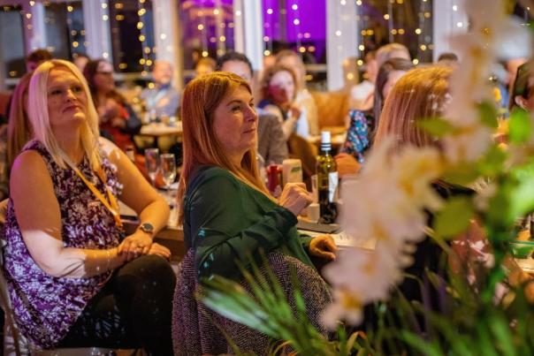 People seated at a table looking at the stage during the EMEA Summit 2025 awards ceremony.