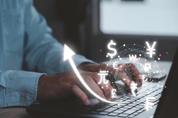 Person using a smartphone with glowing currency icons, symbolising digital monetisation opportunities.