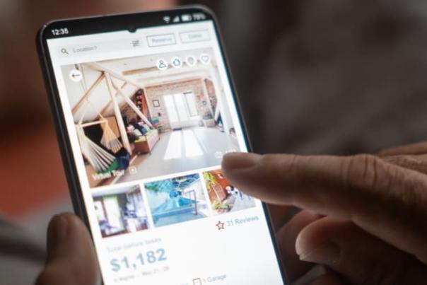 A person browsing short-term rental listings on their mobile device.