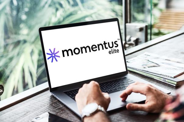 A person using a laptop computer open to the Momentus Elite logo, signifying the new integration with Simpleview CRM.