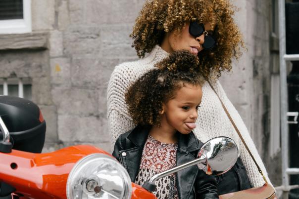 A mother and daughter acting goofy and sticking their tongues out while traveling.