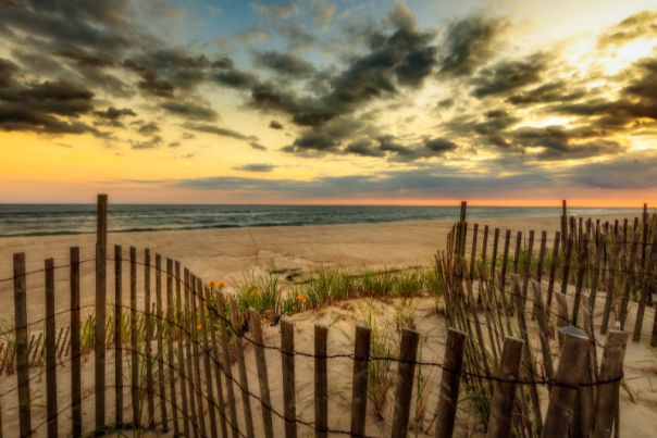 A beach with a dramatic, cloudy sunset on Long Island, New York