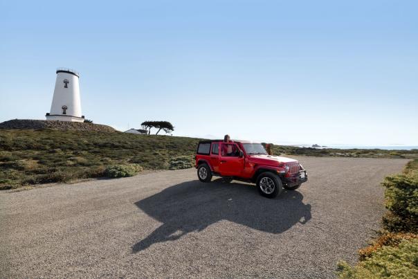Person getting out of car with lighthouse in the background