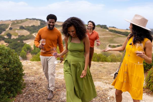 Friends walking through a vineyard in Paso Robles, San Luis Obispo County, California
