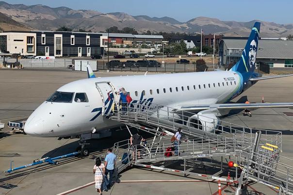 Travelers Embark on an Alaska Airlines Plane