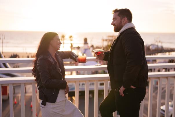Couple enjoying a drink at a rooftop bar overlooking the ocean