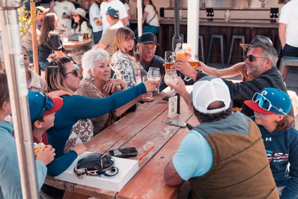 Group of people of varying ages sitting and raising glasses together