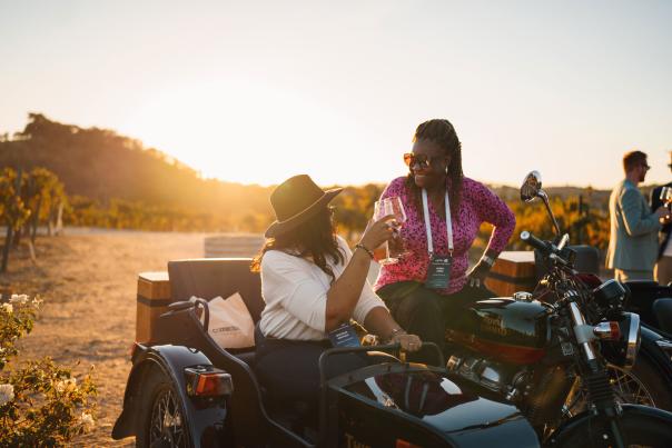 Ladies on a sidecar motorcycle drinking wine