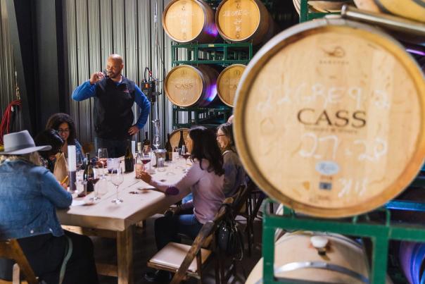 Wine tasting at a table among wine barrels