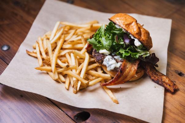 Fully loaded burger and fries on parchment paper
