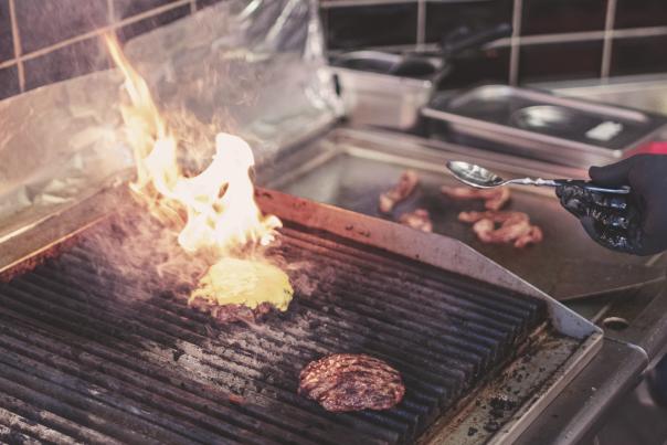 cheeseburgers being grilled in food truck