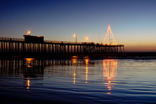 Lit up Christmas tree at end of Pismo Pier during holiday season