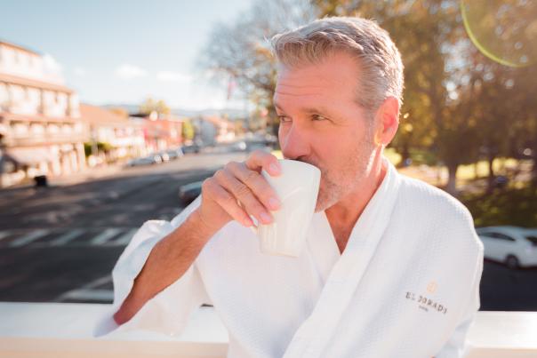 A silver-haired gentleman drinking coffee in a bathrobe above the Sonoma Plaza