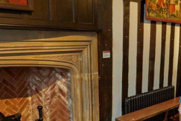 Women following guide book to explore the interior of Tudor House