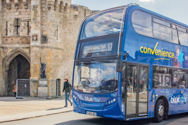 Number 17 double decker Bluestar bus driving on road past Bargate