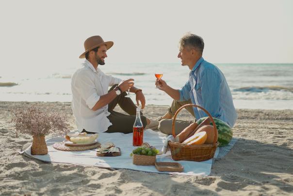 Gay couple picnicking on beach