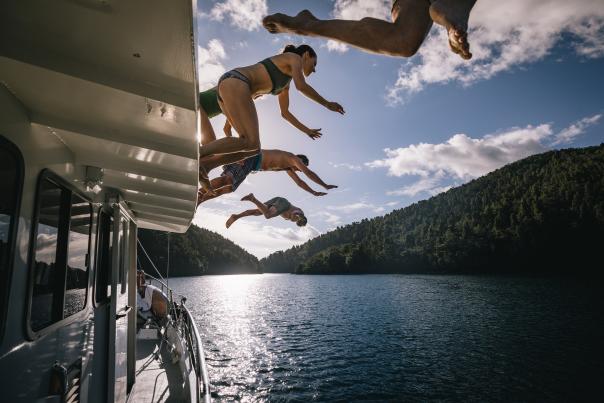 People jumping of  boat in Doubtful Sound