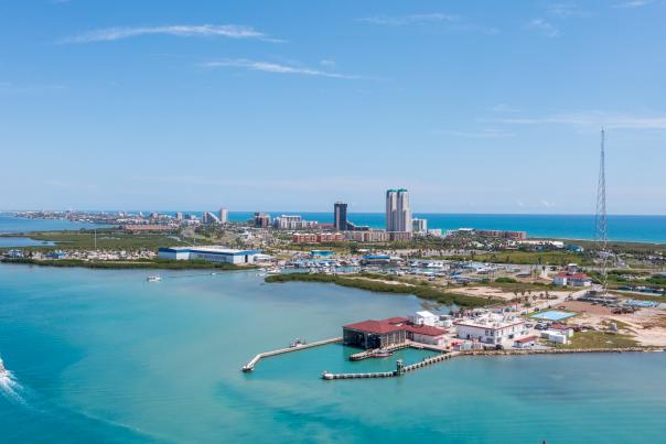 Aerial view of South Padre Island, Texas showing Laguna Madre Bay, marinas, and the skyline of beachfront hotels and resorts