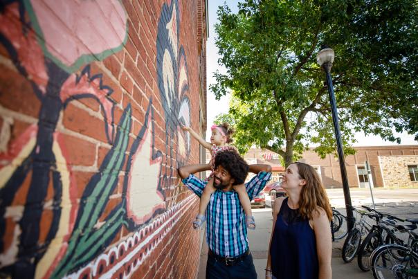People exploring downtown Stevens Point in the Summertime by the Polish Chicken Mural