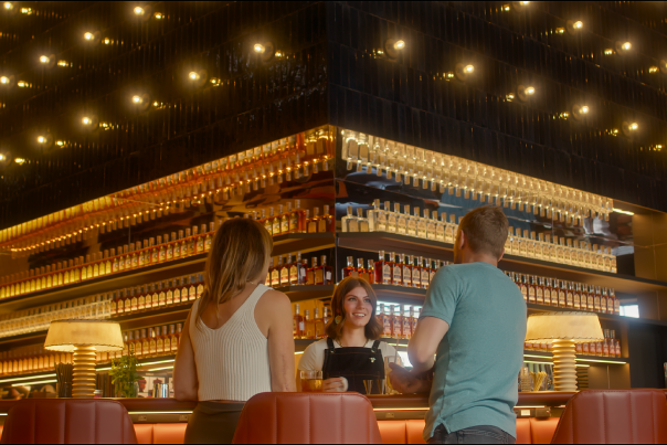 two people standing in front of the mixology bar ordering a cocktail