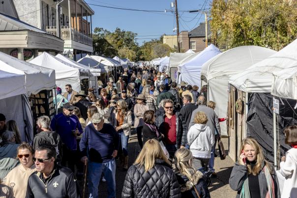 Pop-up tents line either side of Columbia Street during the Covington Three Rivers Art Festival, and shoppers fill the street.