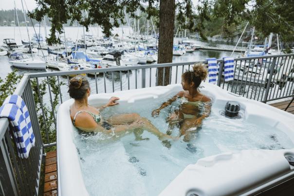 Two women soak in a hot tub overlooking the marina.