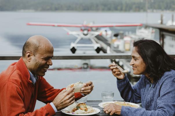 A couple dines on patio, overlooking the floatplane dock.