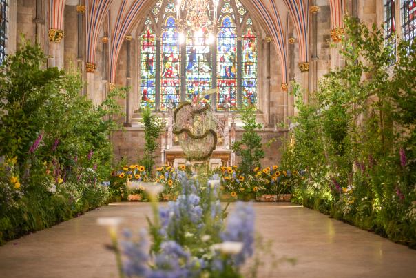 Floral display and stained glass window at the Festival of Flowers at Chichester Cathedral