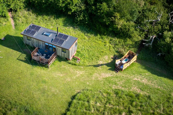 Aerial view of the Eco-Cabin and wood-fired hot tub set in a secluded meadow in the Sussex countryside