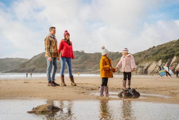 A family playing on swansea beach in the winter