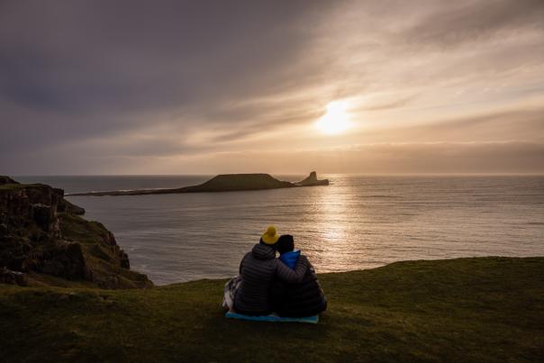 A couple watching the sunset at Rhossili