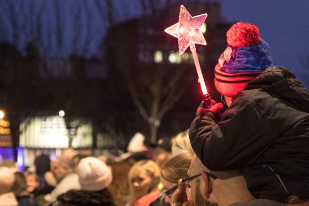 A young boy holding a star wand at the Christmas Parade