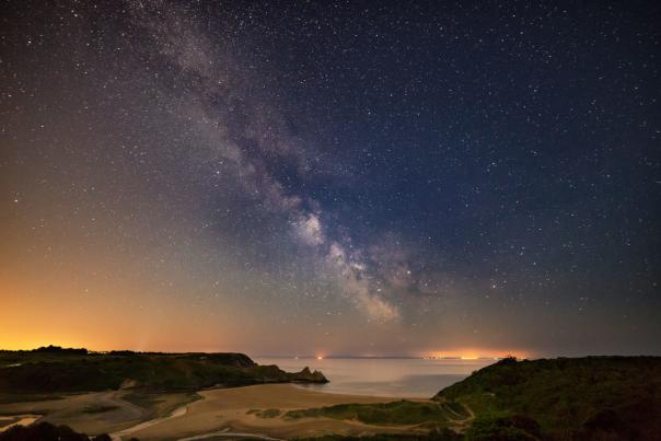 Three cliffs coastline at night with sky full of stars