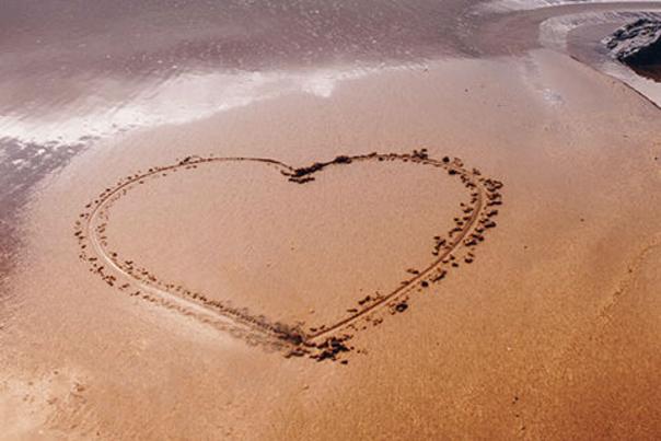 A heart drawn in the sand on a beach
