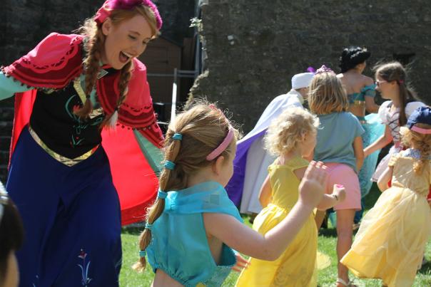 A woman and small girls dresses as princesses