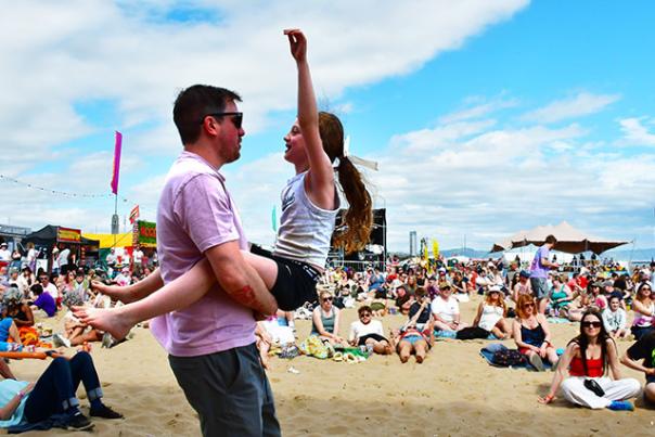 A man dancing on the beach with a girl