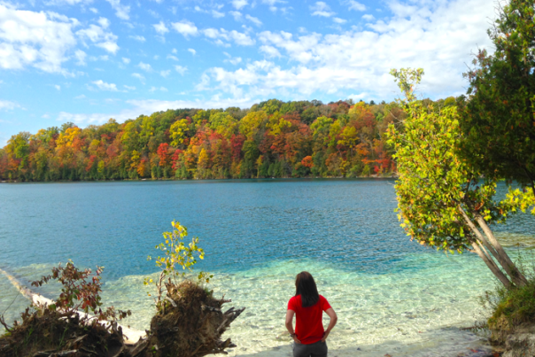 Woman in Red Shirt Overlooks Beautiful Blue Water on a Fall Day at Green Lakes State Park