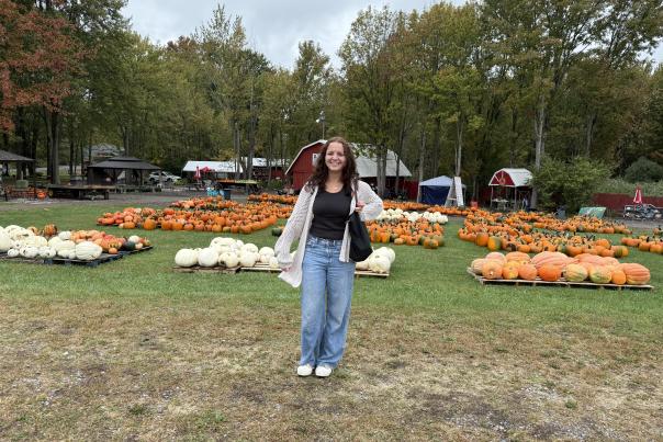 Young woman posing in front of pumpkins