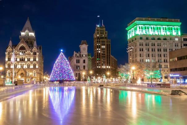 Evening photo of Clinton Square Ice Rink and Holiday Tree lit up in Syracuse, NY