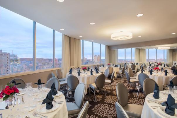 Ballroom set up at the Crowne Plaza Over looking the city skyline with grey chairs and floral print rug