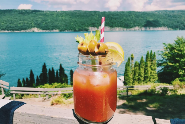 a bloody mary on a railing looking over a lake
